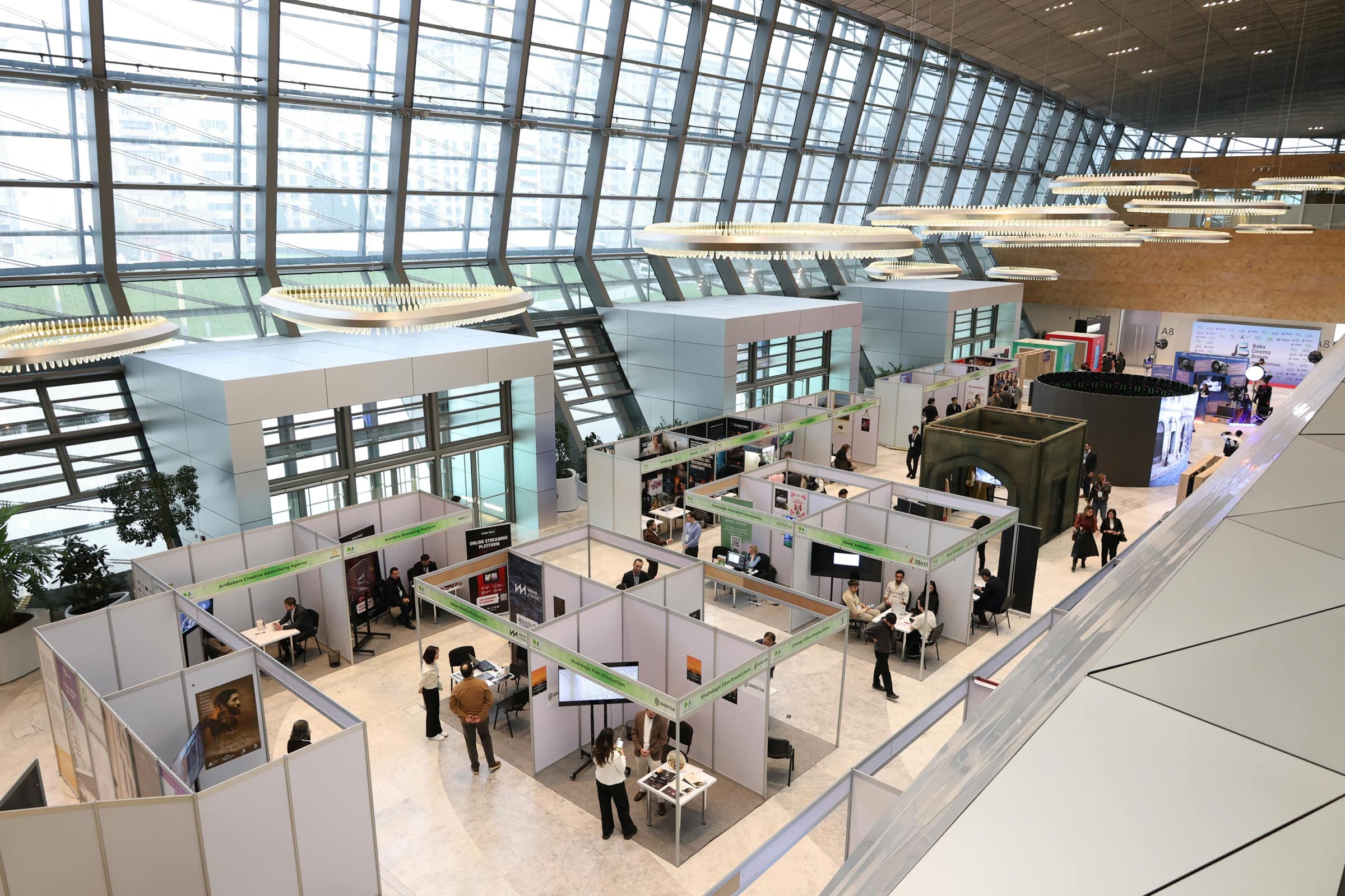 Wide view of a modern trade show floor with exhibition booths and attendees
