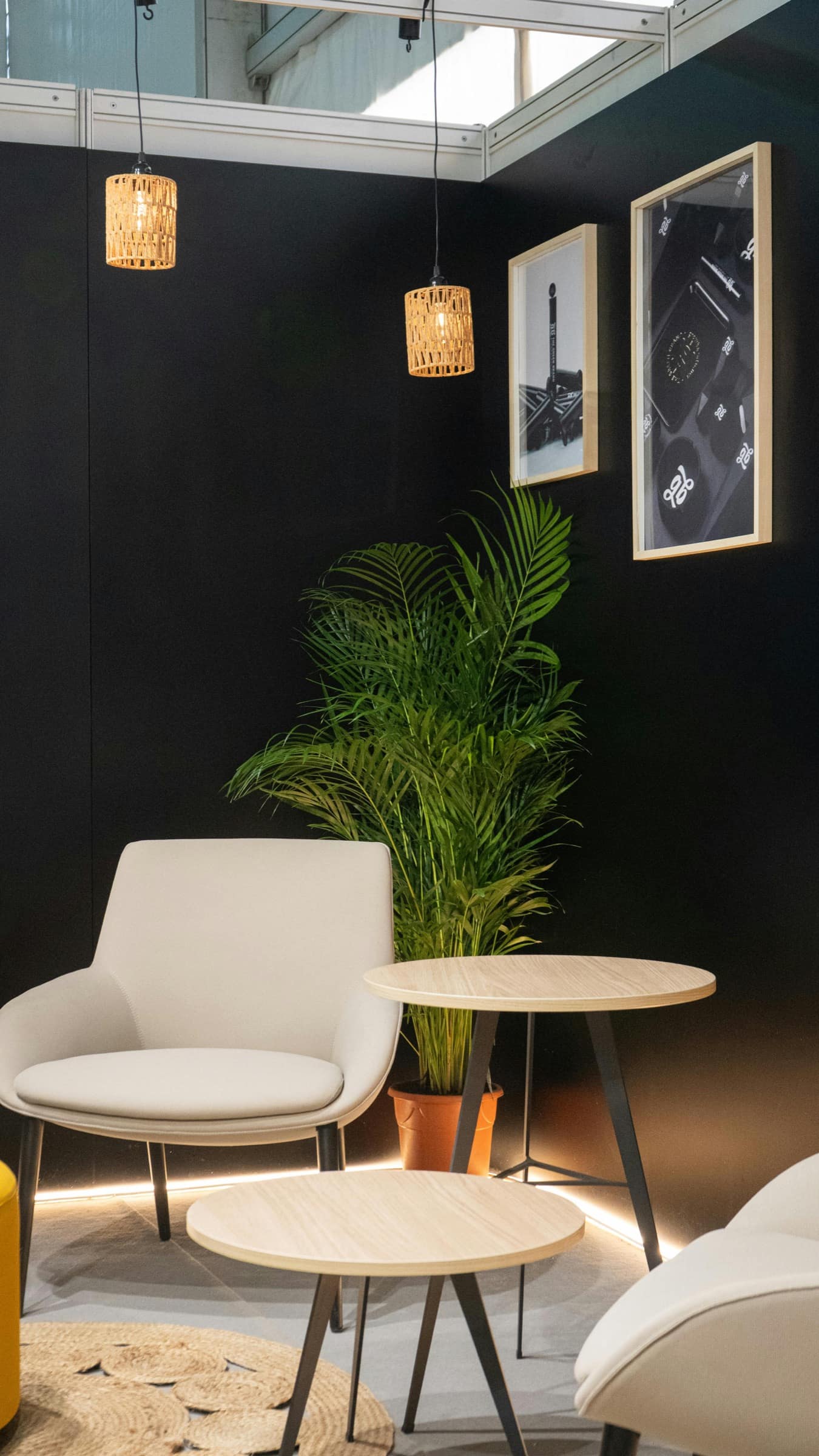 A lounge-style trade show booth with warm lighting, chairs, and soft finishes