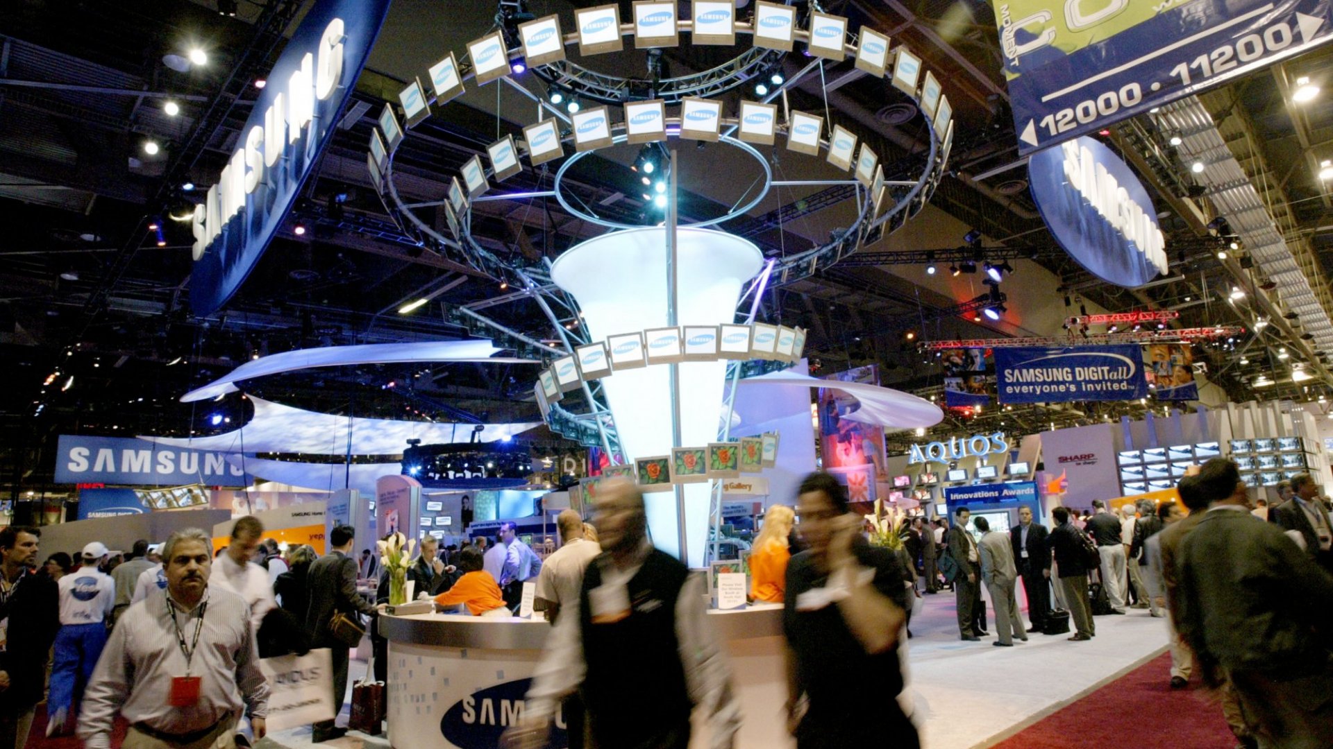 Exhibitors and attendees moving through a large convention expo hall