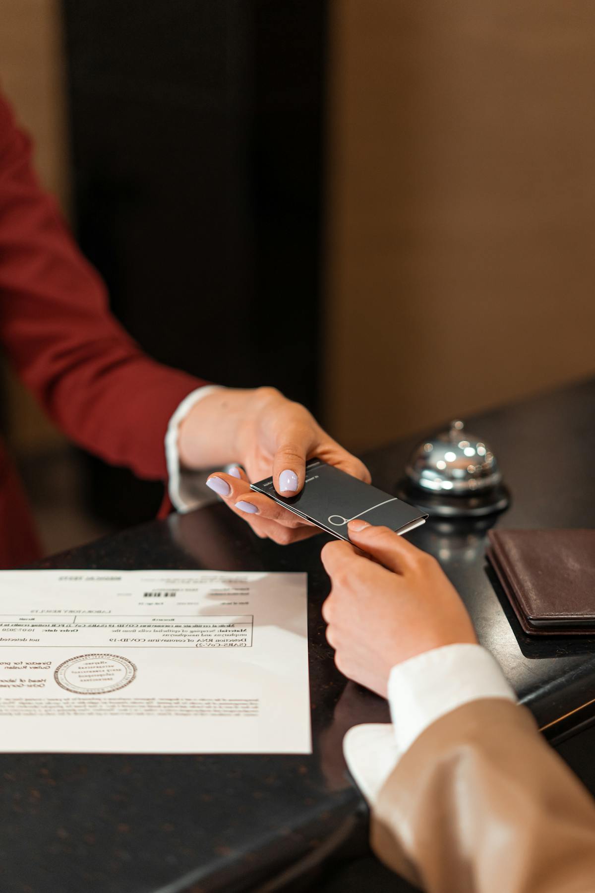 Hotel front desk handing a room key card to a traveler
